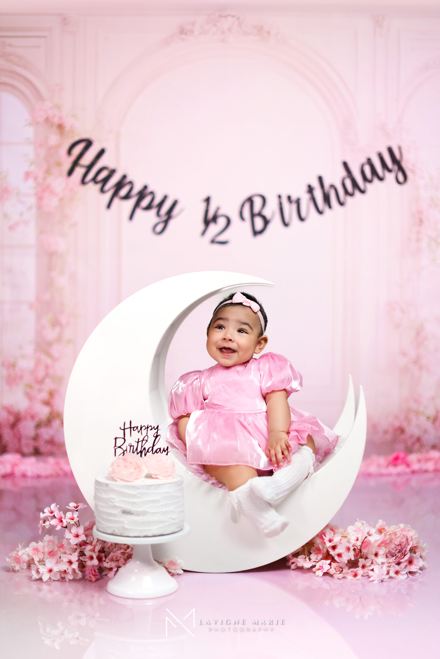 6 months baby studio photoshoot featuring a happy baby captured in soft light with a simple, neutral background.