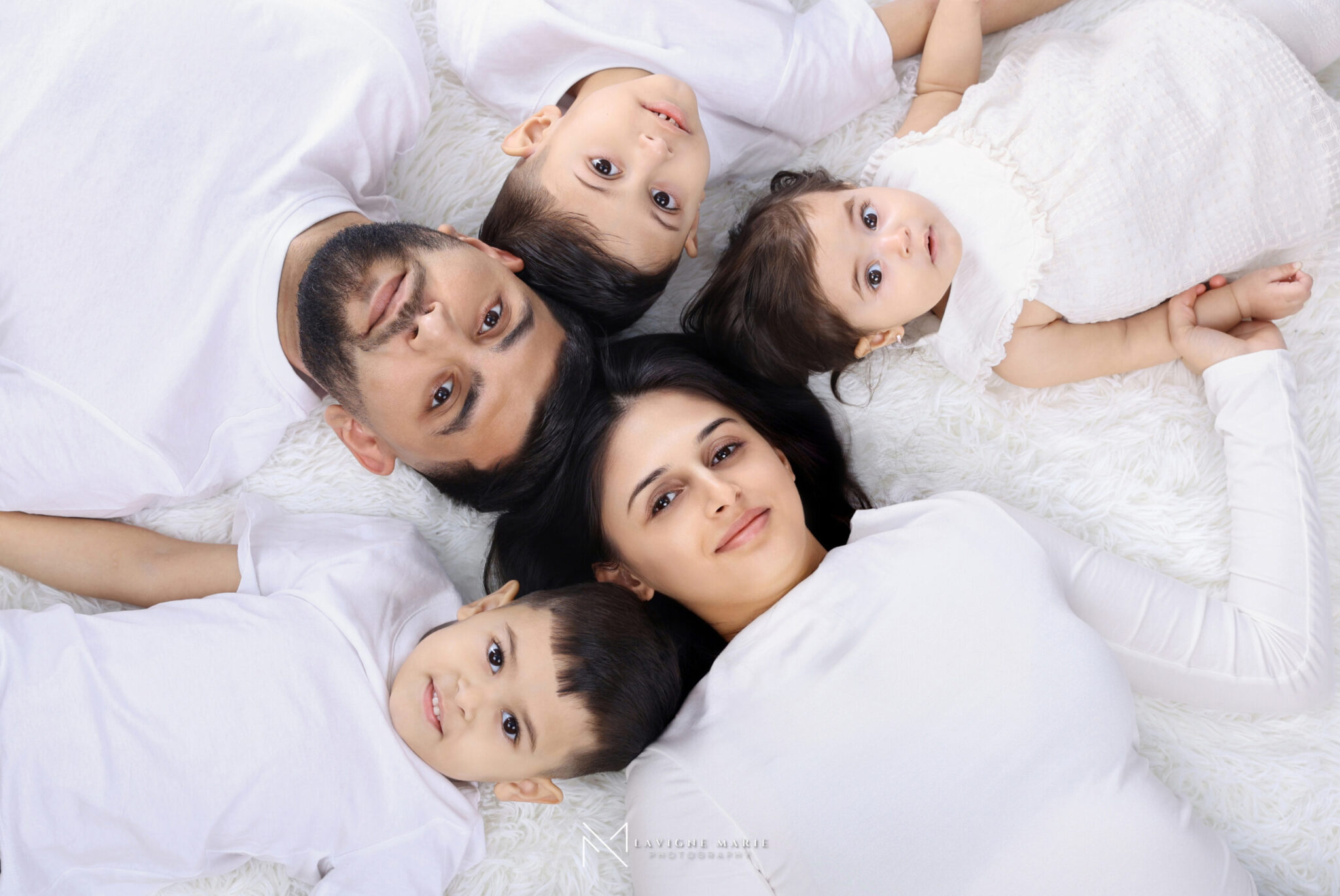 Happy family posing together during a professional family photoshoot, smiling and enjoying a relaxed moment