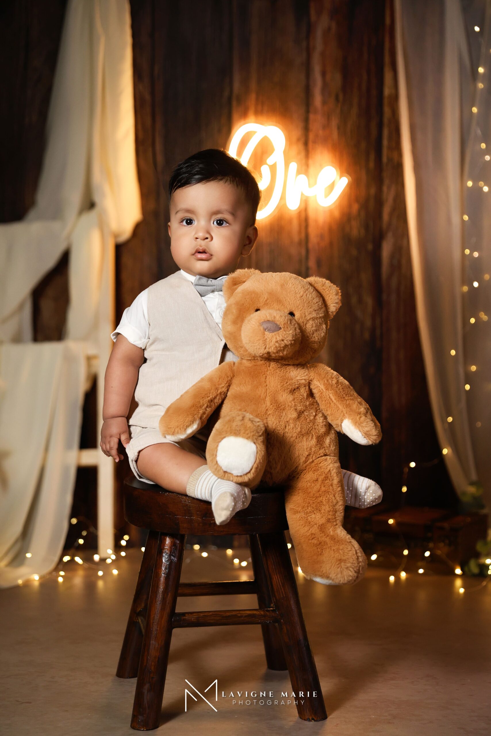 First birthday photoshoot of a baby with a teddy bear prop