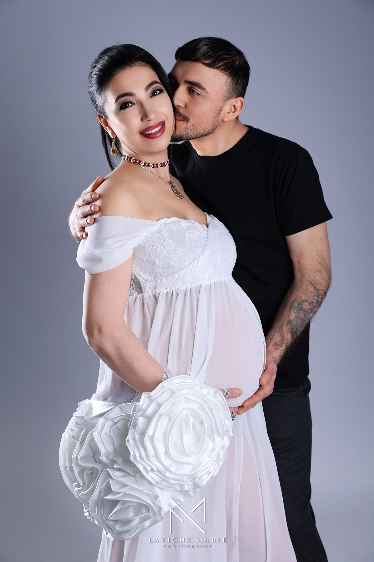 Maternity couple photoshoot in London capturing an intimate moment between expecting parents in a professional studio setting.