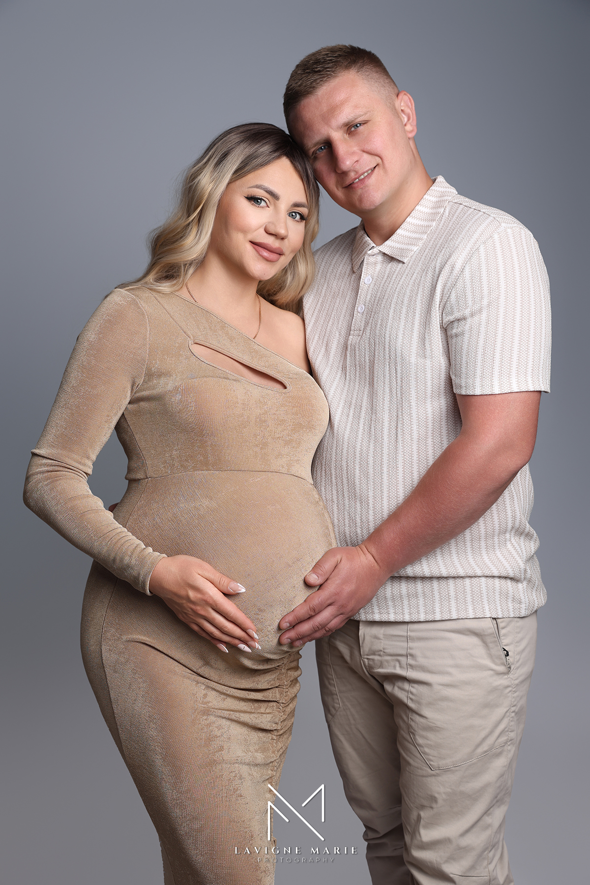 Pregnant couple with their child sharing a tender moment during a maternity couple family photoshoot