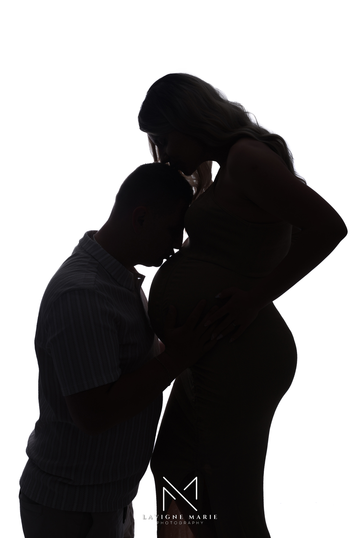 Silhouette maternity photoshoot in London featuring a pregnant woman posing against soft studio lighting