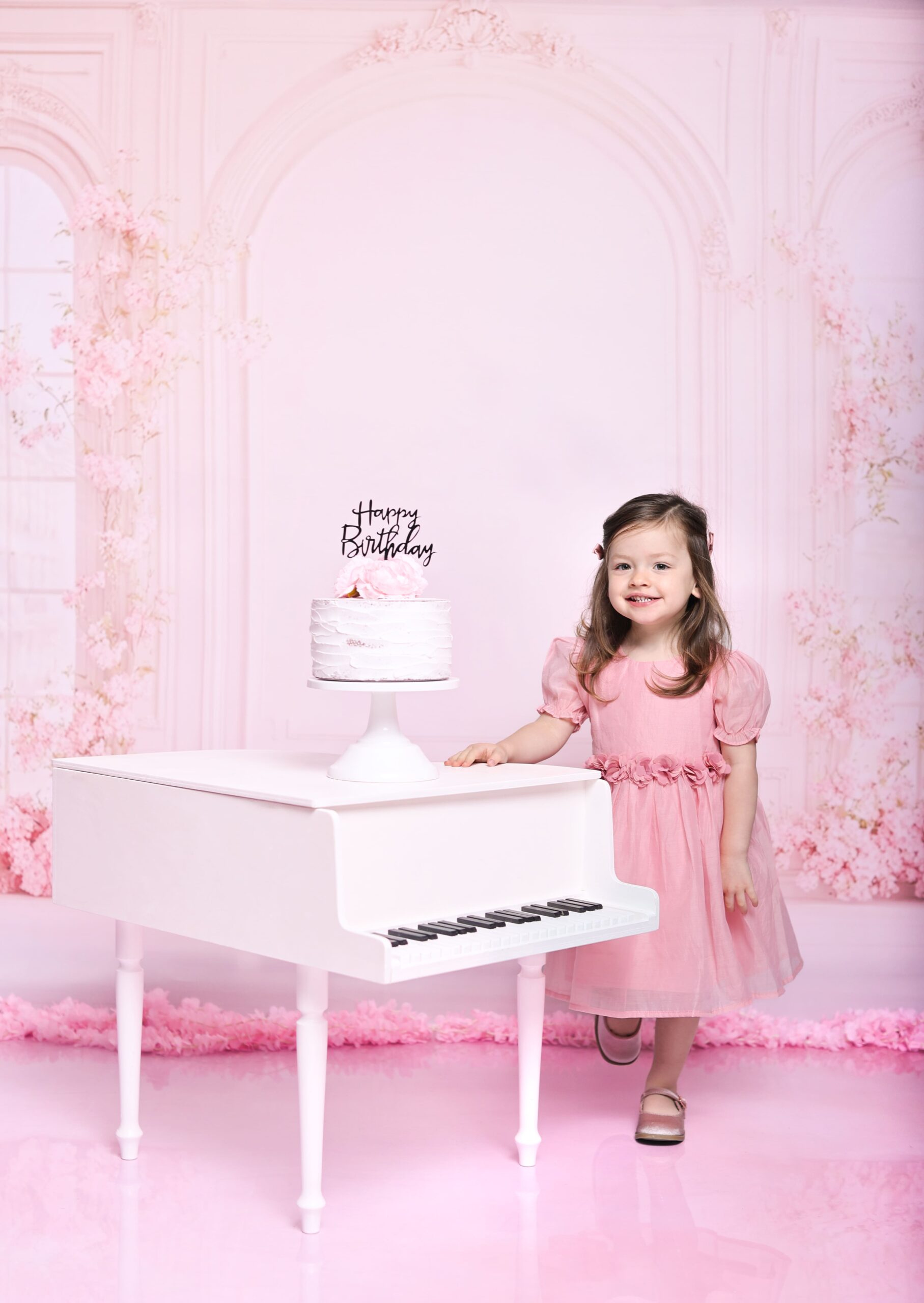 Children posing in a professional studio session with a soft pink backdrop