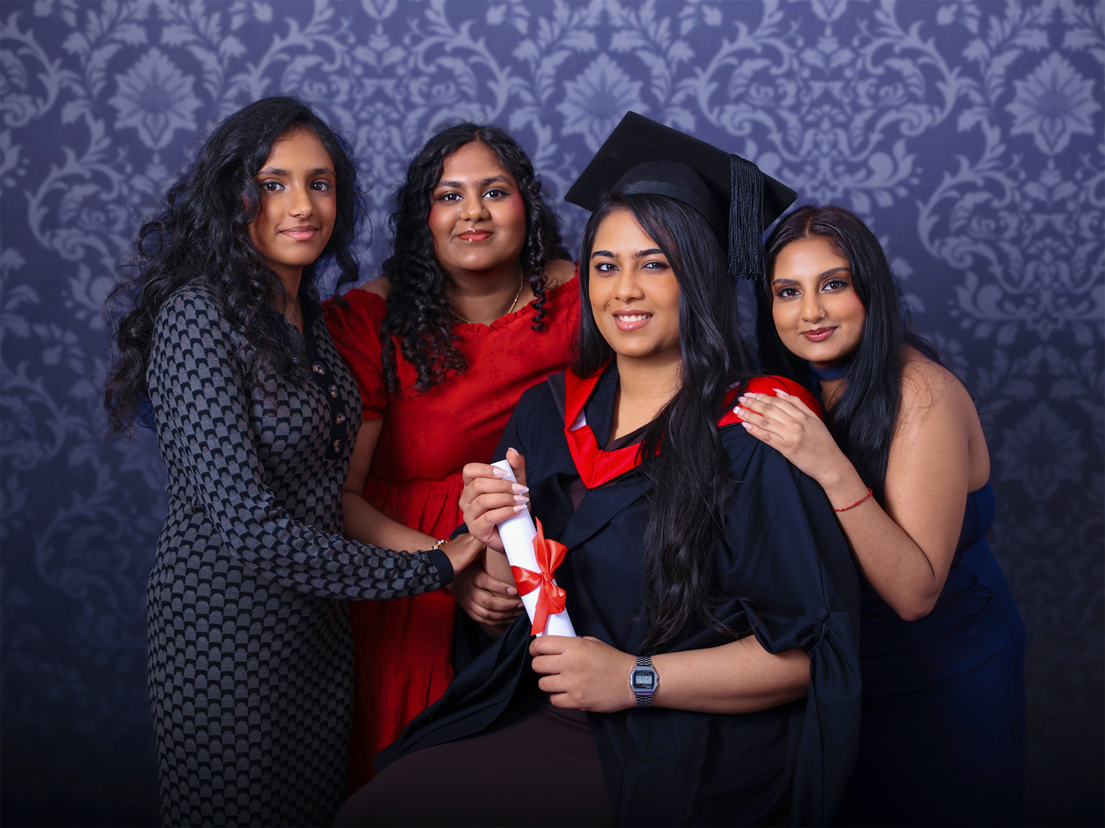 Graduation family studio session with graduate posing with parents in a professional photography studio