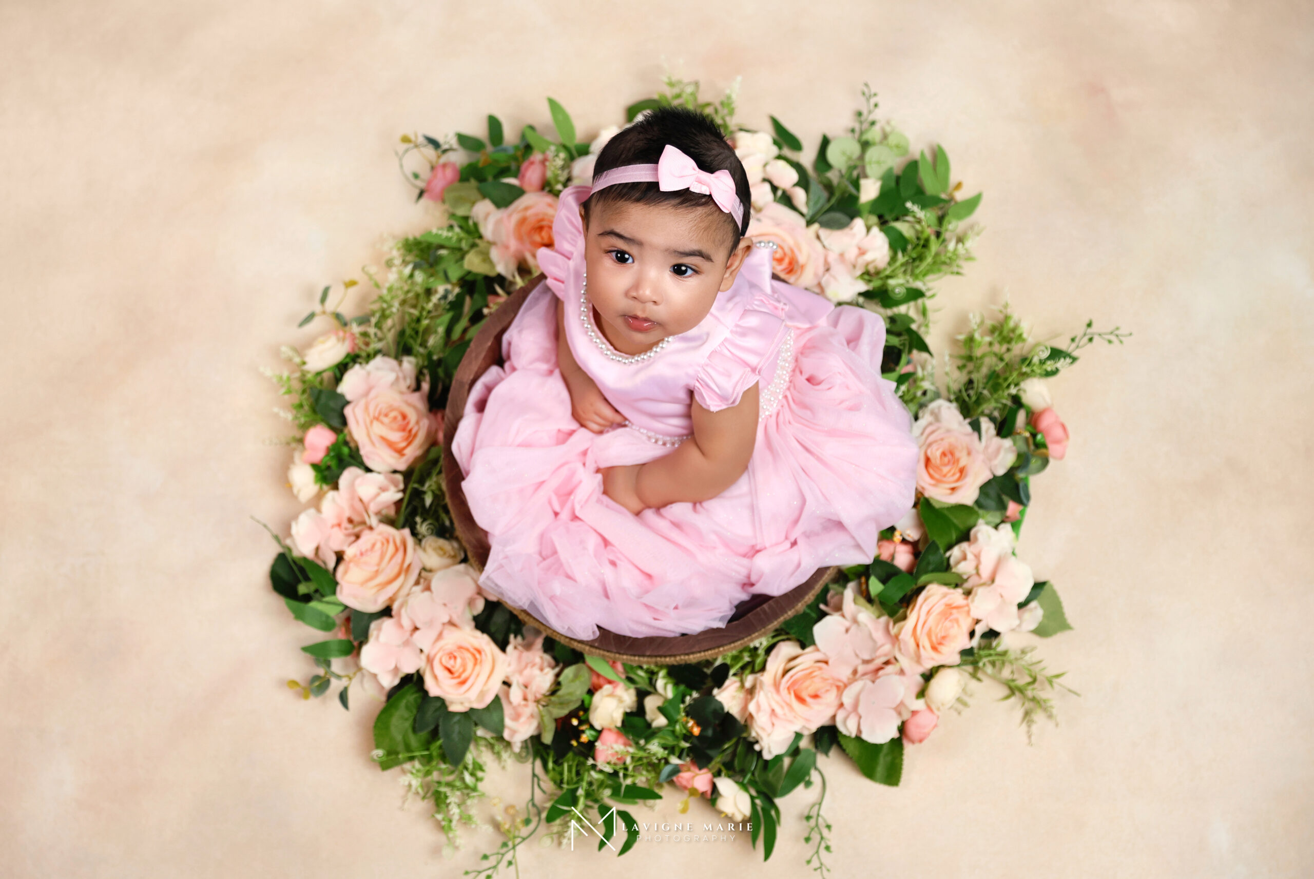 6 months children studio photoshoot showing a smiling baby sitting confidently in a minimalist photography studio.
