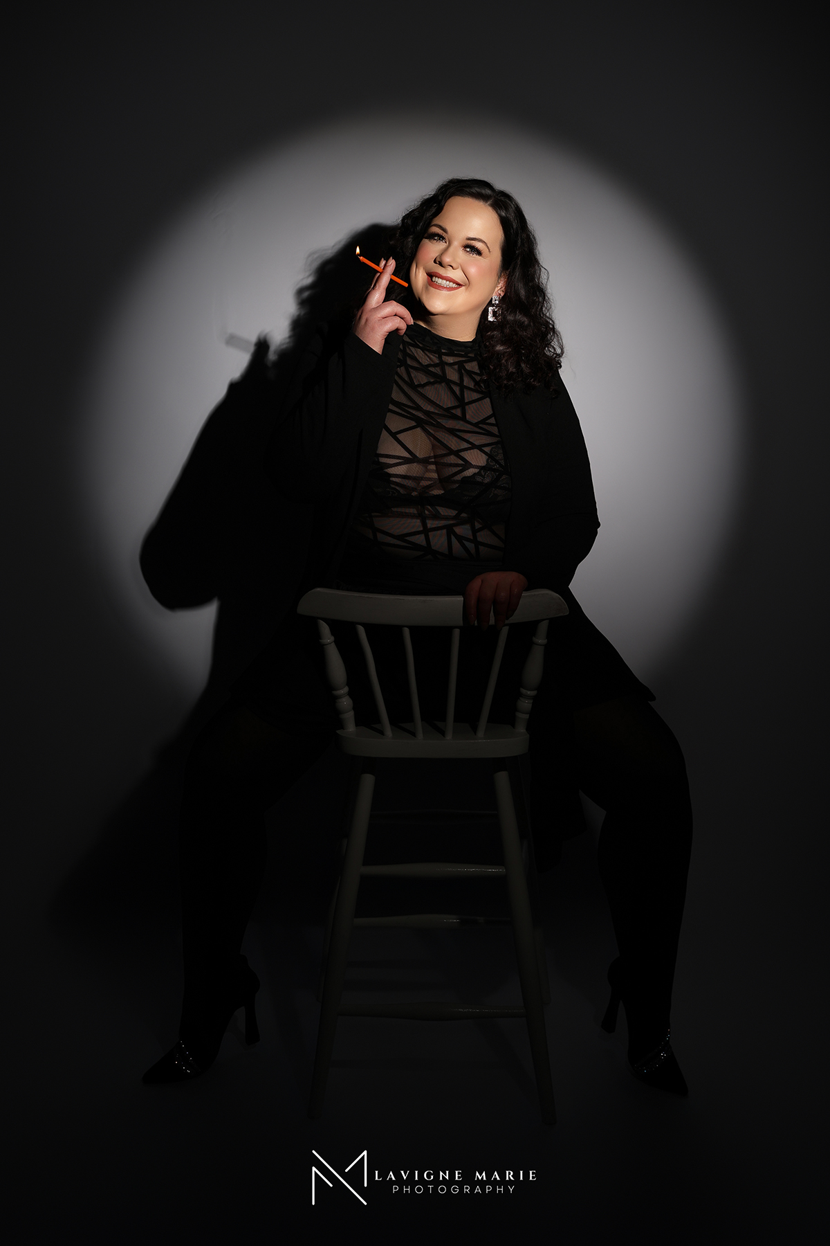 30th birthday spotlight photo session in London studio with glamorous black backdrop and professional lighting