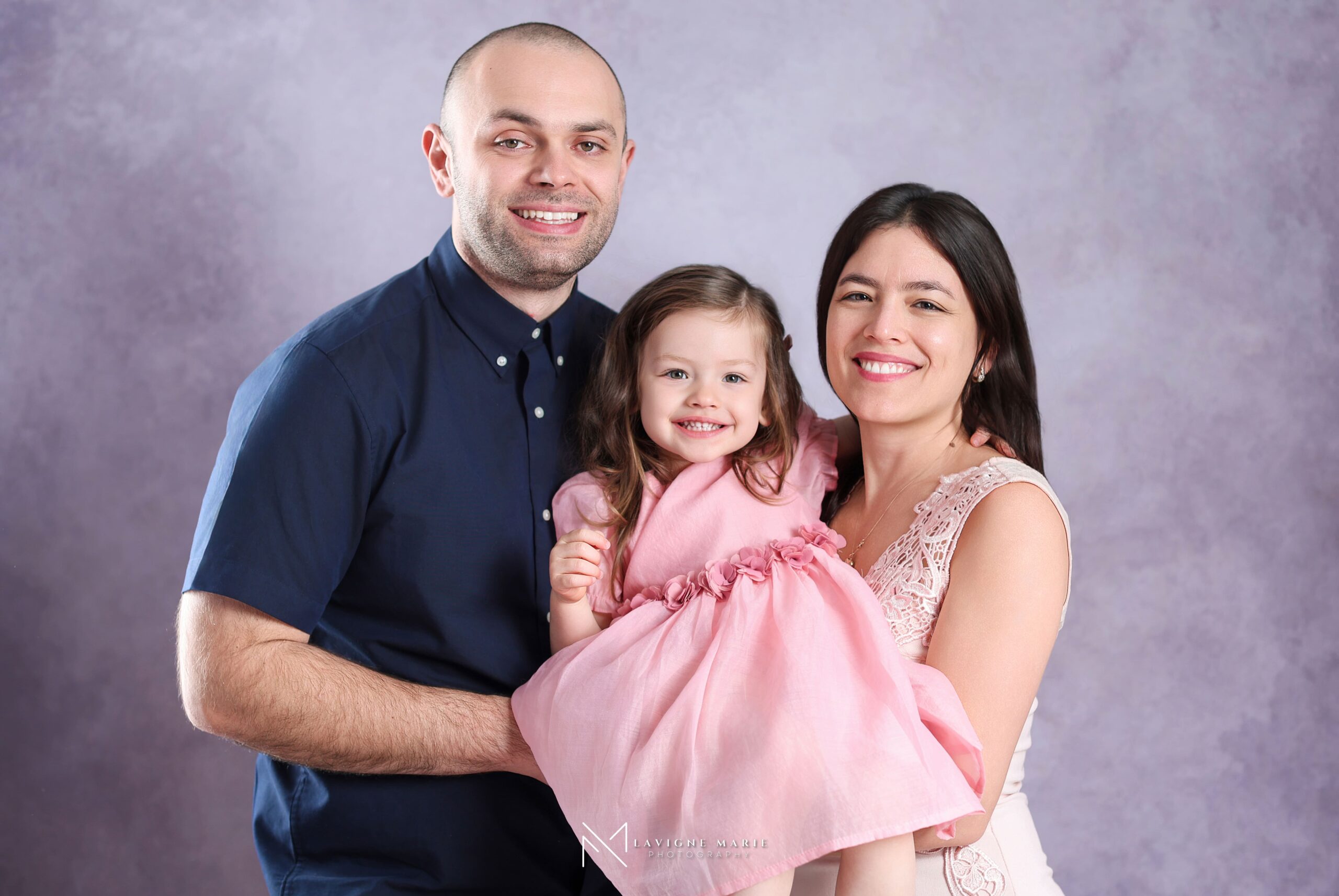 Happy family with a toddler during a professional studio photo session in London, captured in a bright and welcoming photography studio.