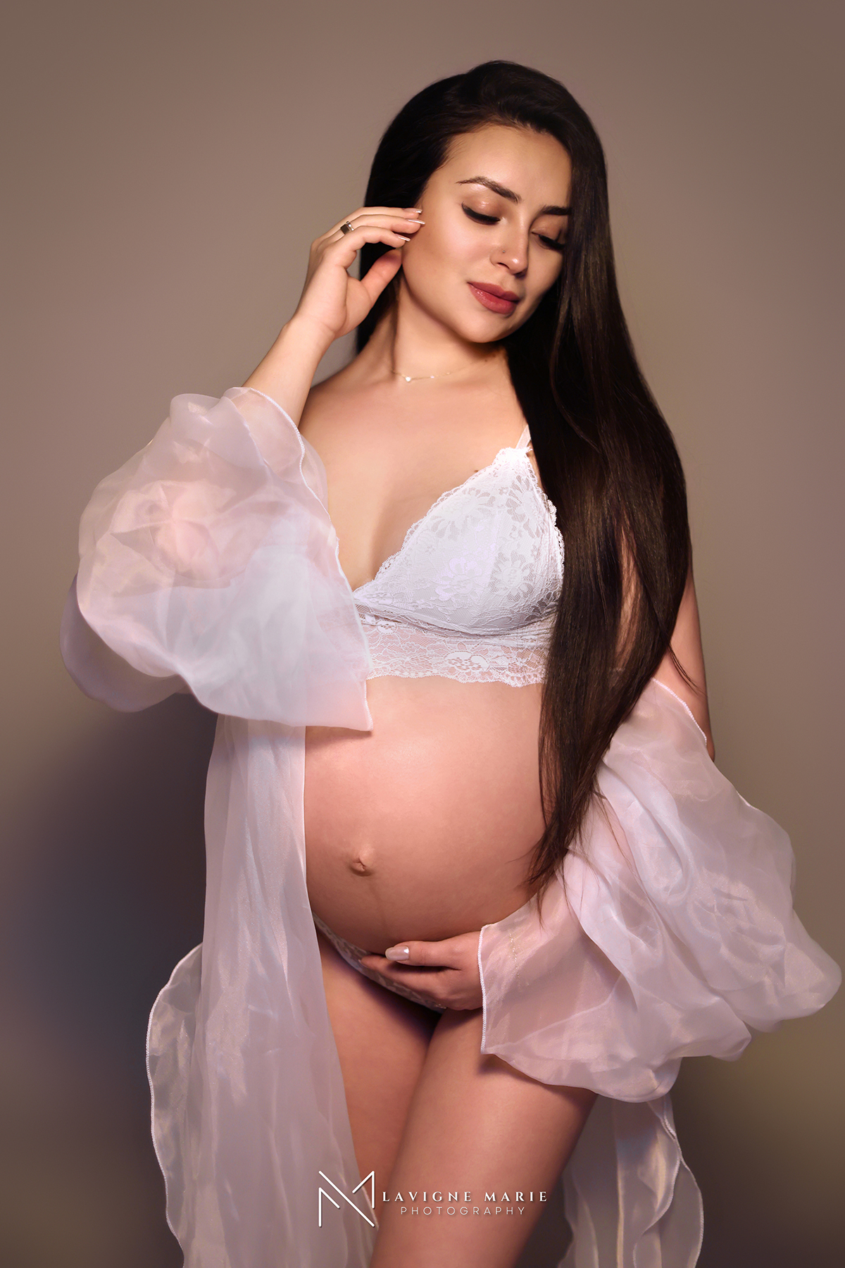 Professional female maternity photographer in London adjusting lighting during a pregnancy photoshoot