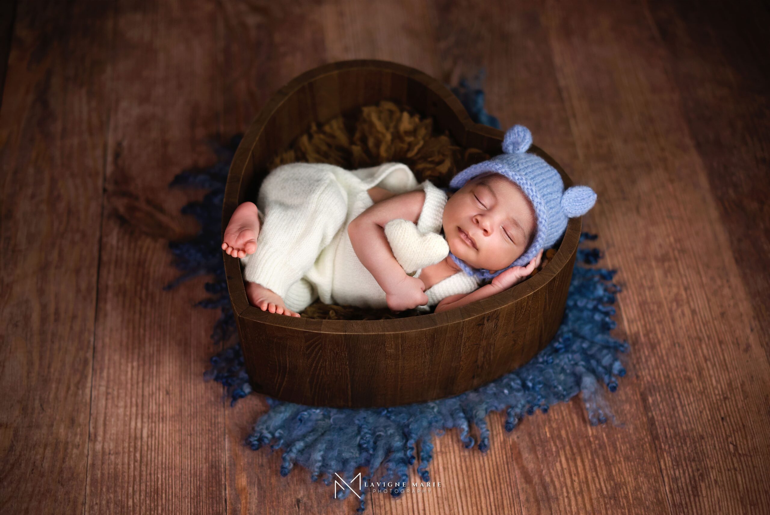 Newborn baby photoshoot on a warm brown backdrop with soft studio lighting and natural posing