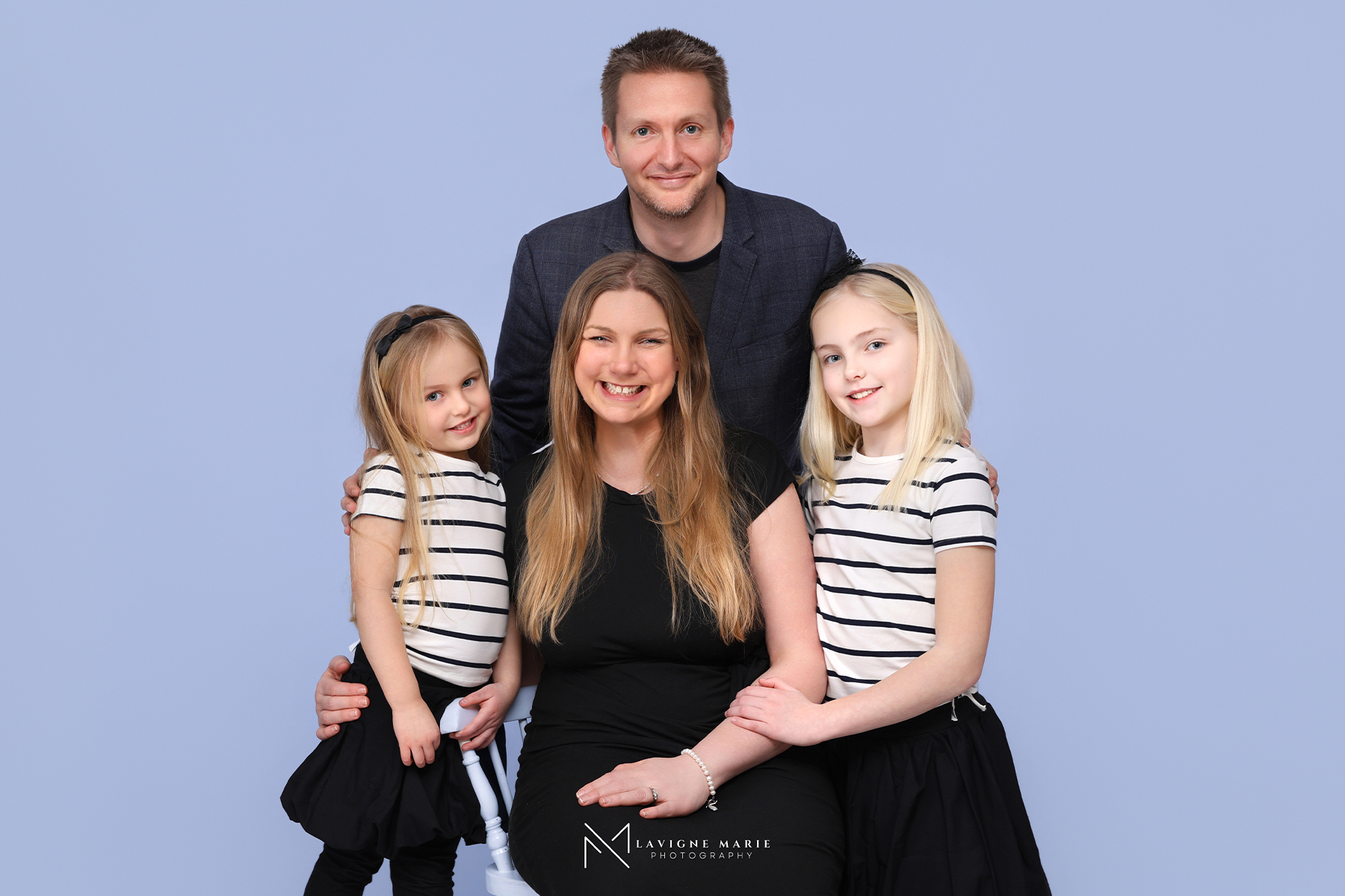 Family portrait photography session with plain white background and professional studio lighting.