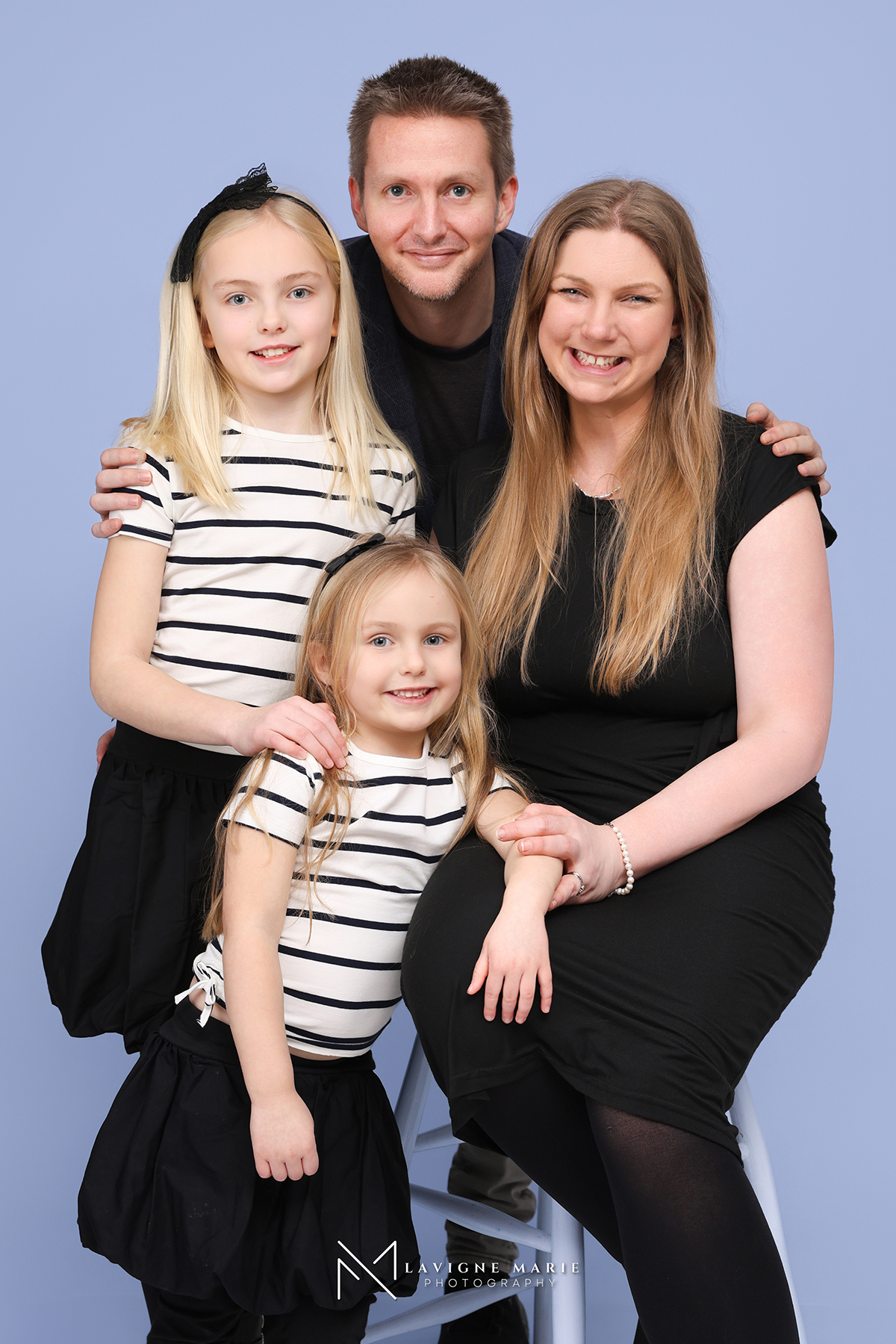 Family enjoying a professional studio photo session in London with soft lighting and classic portrait setup.