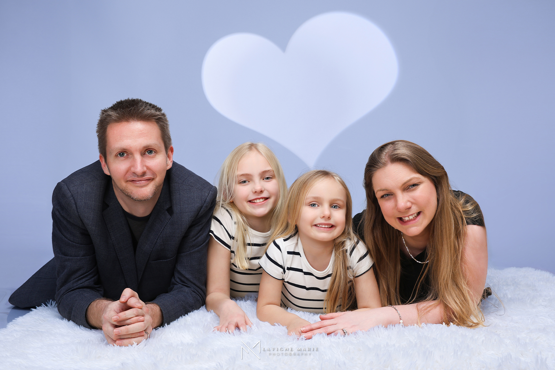 Professional studio family photoshoot in London with parents and children posing naturally against a neutral backdrop.