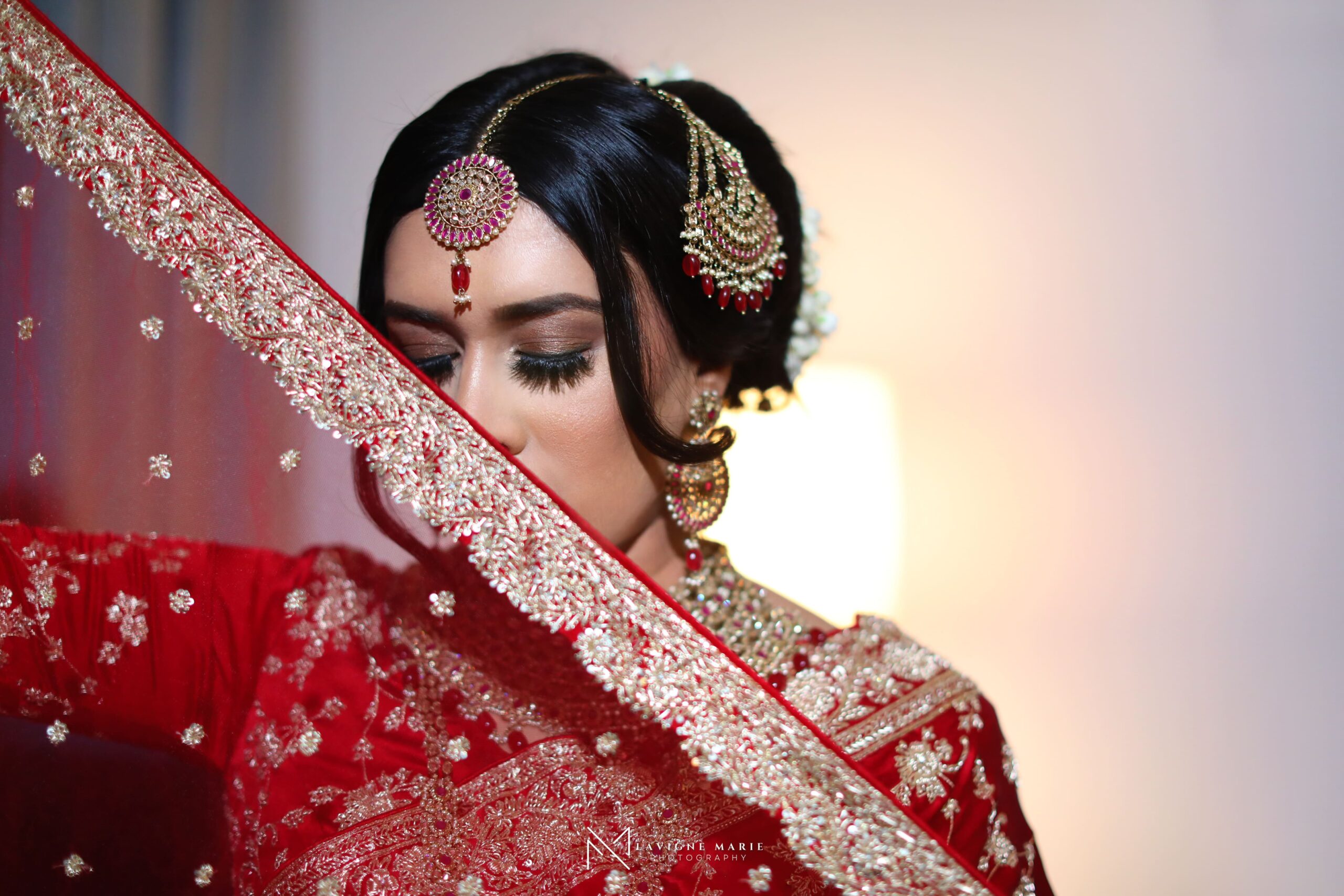 Female Asian wedding photographer in London capturing bride and groom during traditional ceremony