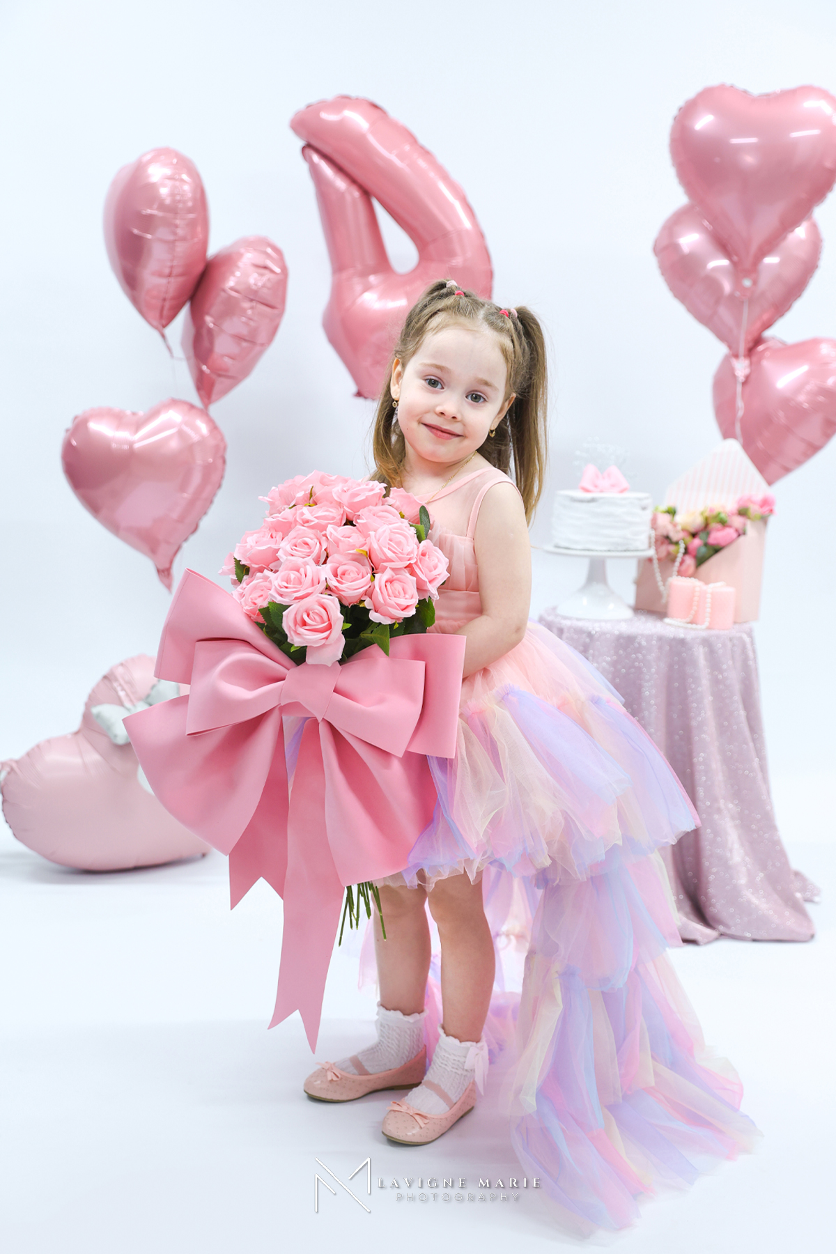Child celebrating their 4th birthday during a professional studio photoshoot with birthday decorations and a portrait-style setup.