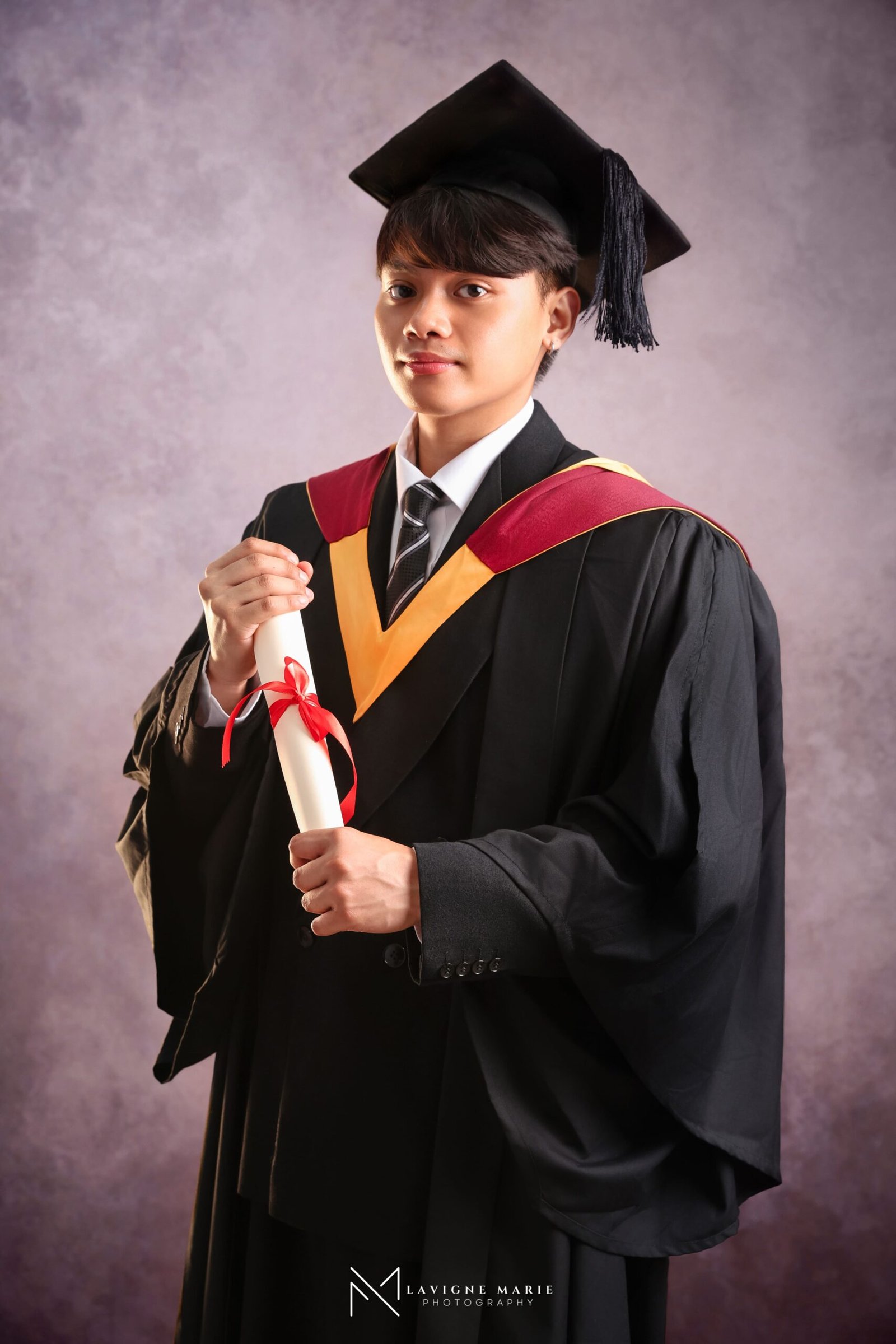Graduate photographed during a professional graduation portrait session in a London photography studio wearing academic cap and gown
