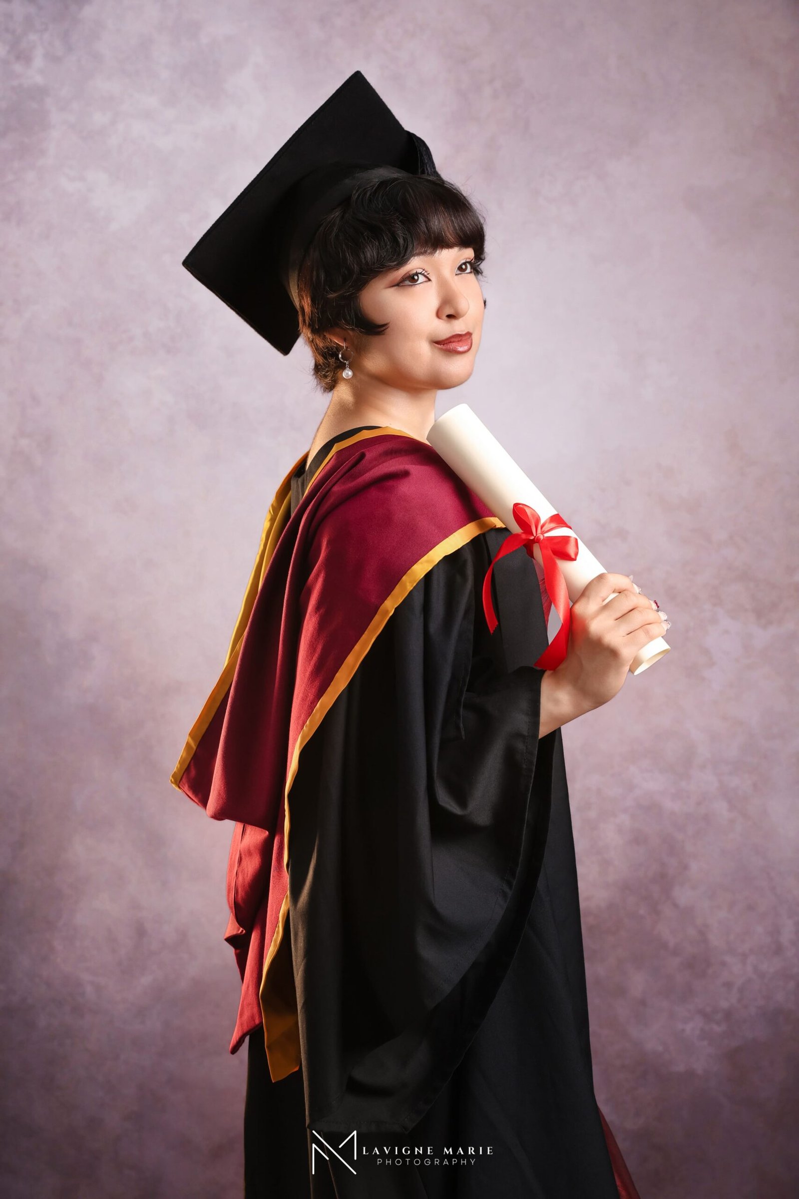 Professional graduation single portrait in London showing a graduate in cap and gown photographed in a studio